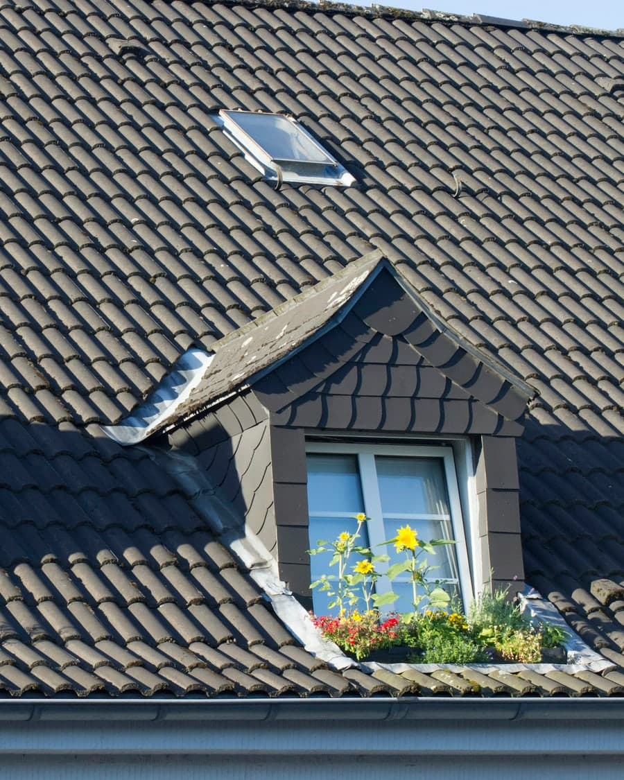 Toit de tuiles anthracite avec lucarne habillée d'ardoise et fenêtre de toit
