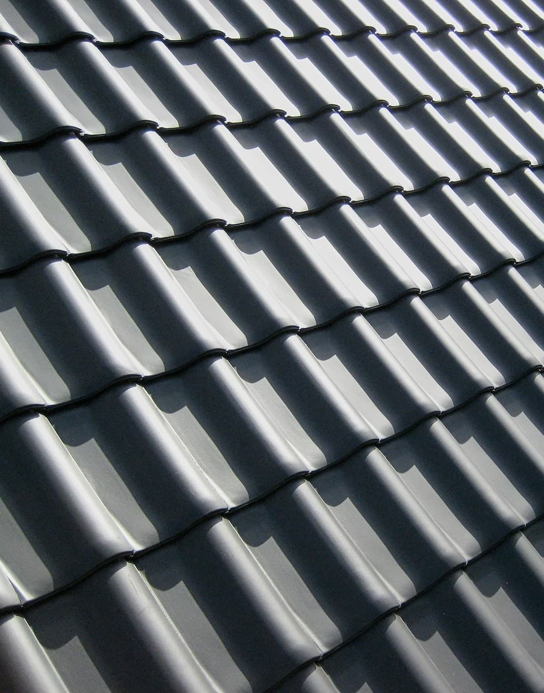Tuiles céramiques sombres d'une couverture, en lumière rasante
